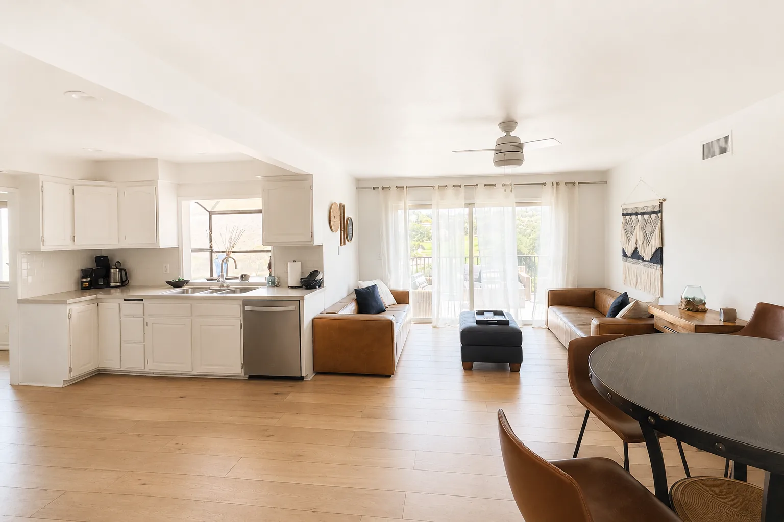 Sunlit open-plan living room and kitchen prepared for guest arrival